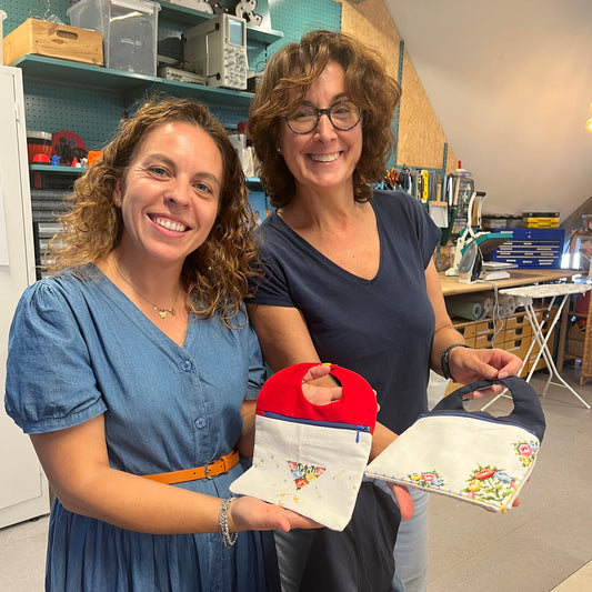 Bildet viser to glade personer som har lært å sy på nybegynnerkurs symaskin